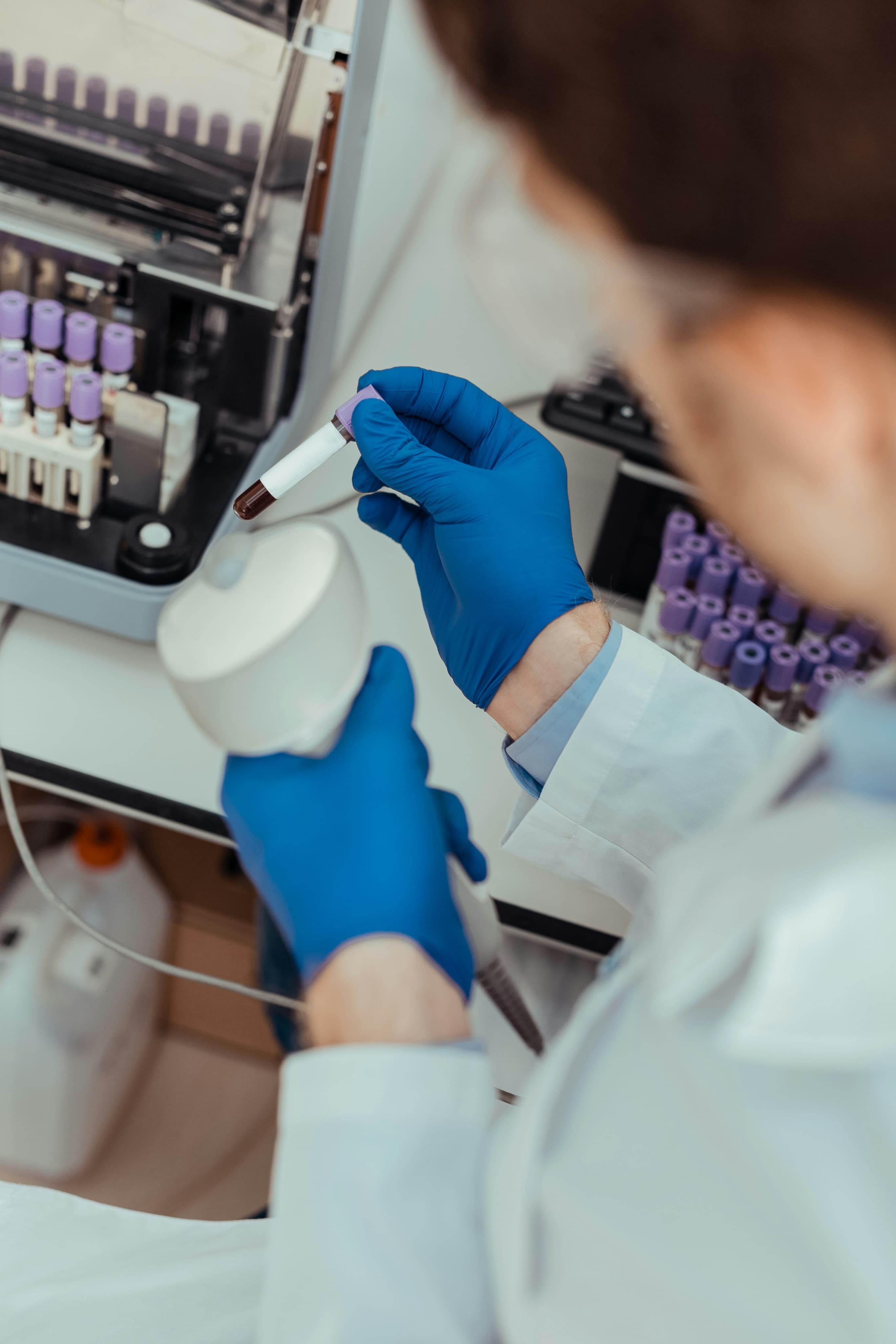 Lab worker in blue gloves.